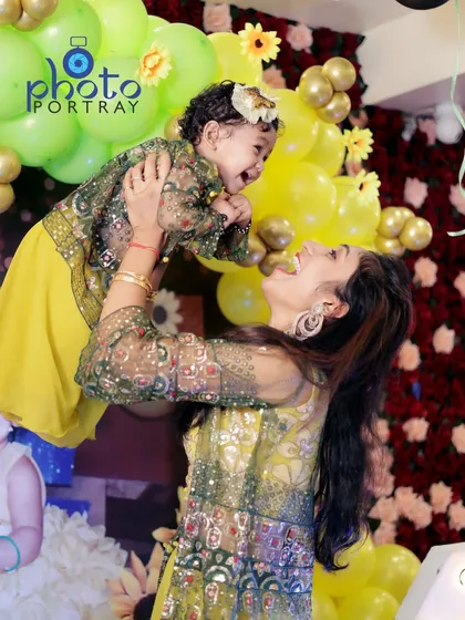 A mother lifts her daughter in the air, both sharing a moment of pure happiness. I look for these dynamic, emotional shots during family events to create photos that feel alive and full of love.