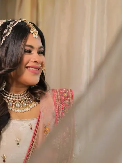 A dreamy, happy bride on her wedding day. We created a soft glam look with beautiful wavy hair to match her elegant pastel lehenga.