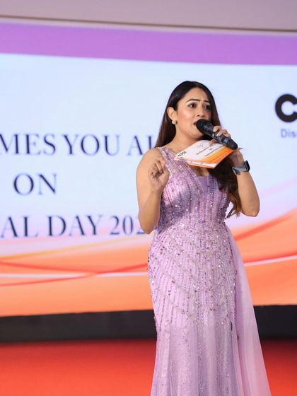 A focused shot of me hosting on stage. I am committed to delivering a flawless performance at every corporate event I host.