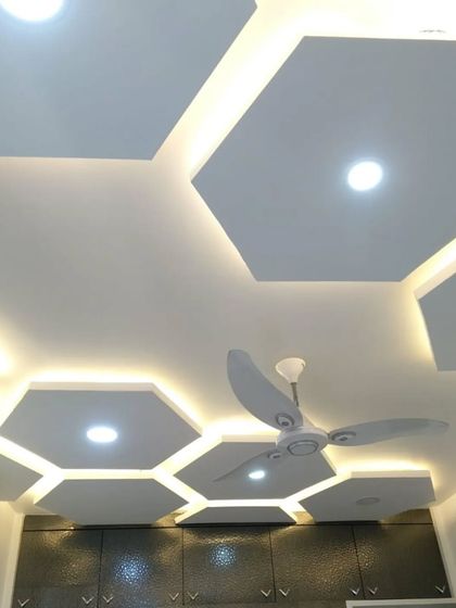 A look at the intricate hexagonal false ceiling design. The combination of direct and indirect lighting creates a layered and luxurious effect.