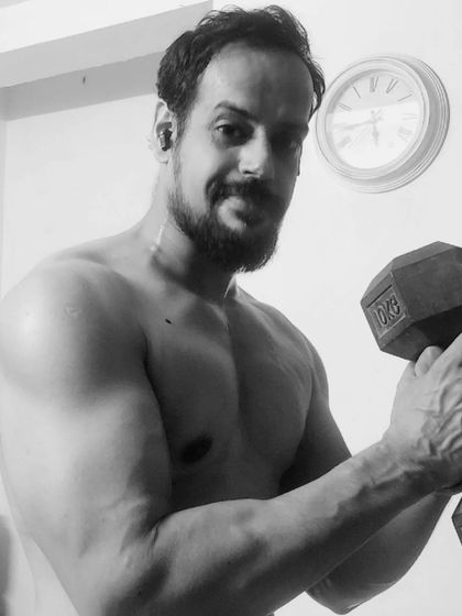 A classic dumbbell curl, captured in black and white to emphasize the focus and effort required. Building strong and muscular arms is a core part of my training philosophy.