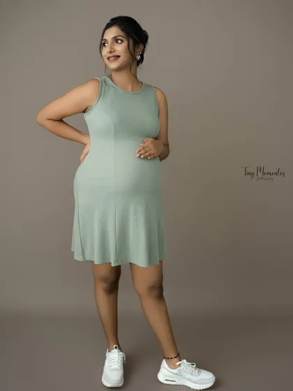 A modern and chic portrait in a casual ribbed dress. The simple styling and confident pose celebrate the beauty of pregnancy in an everyday, relatable way.