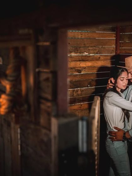 An intimate moment in the rustic, wooden setting of the Western theme. The warm lighting creates a cozy and romantic atmosphere.