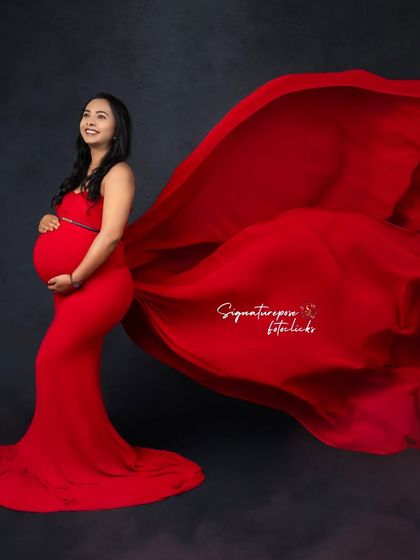 A similar pose showing the beautiful silhouette created by the form-fitting red gown and its flowing train.
