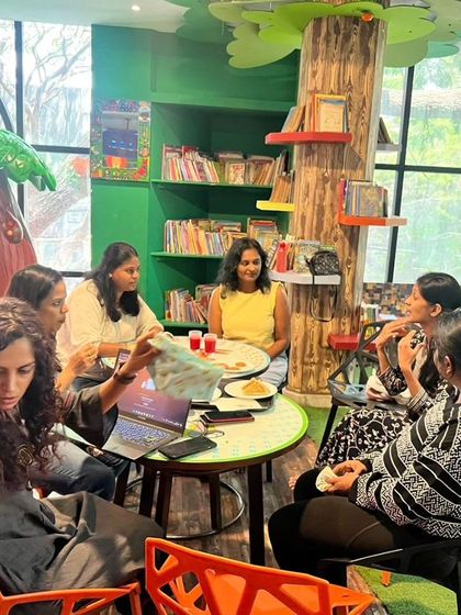 A candid shot from our "Mommy Moments" playdate, where mothers are seen networking and sharing while their children play safely in the background.