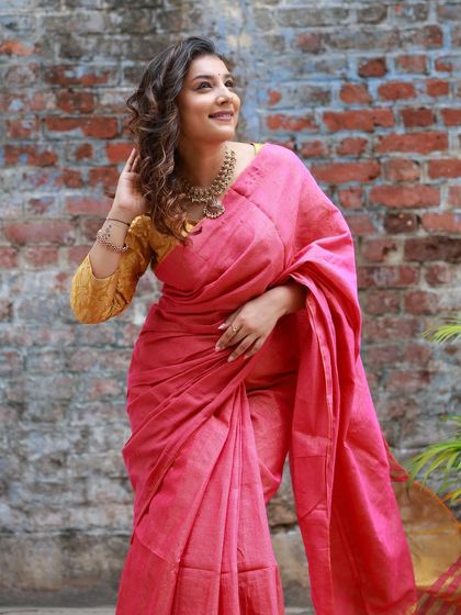 A happy, candid moment from the brand shoot, with the brick wall providing a rustic contrast to the elegant saree.