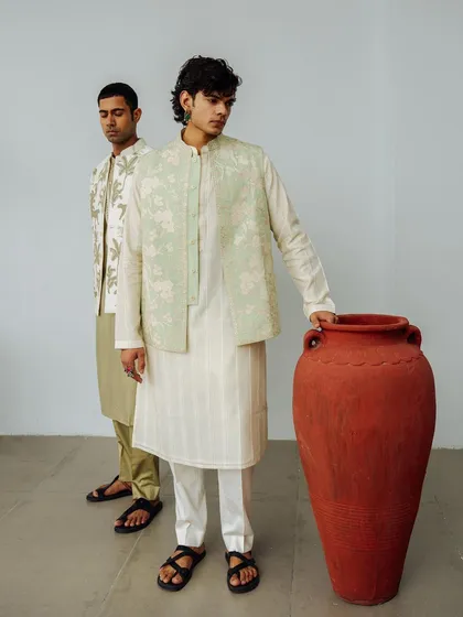 A dual-model look for Wabi Sabi, featuring layered ethnic wear. The composition uses a simple prop and clean background to keep the focus on the clothing.