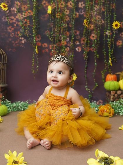 A princess in a sunflower garden. The rich yellow of her dress and the warm, earthy tones of the backdrop create a vibrant and beautiful autumn-themed portrait.