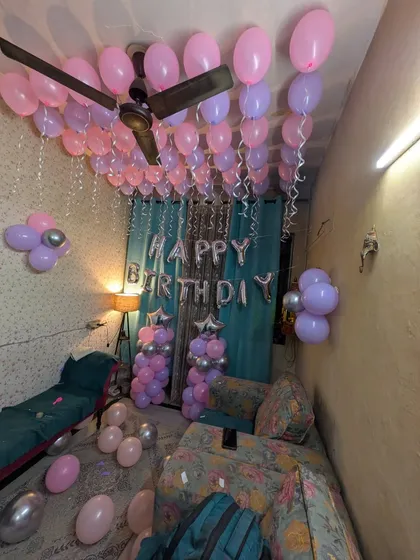 A wide view of the pink and purple birthday room decoration, showing how the balloons fill the space to create a festive environment.