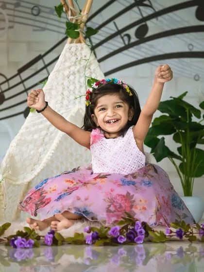 A joyful two-year-old celebrating in a music-themed setup. I love capturing the energy and excitement of toddlers as they grow.