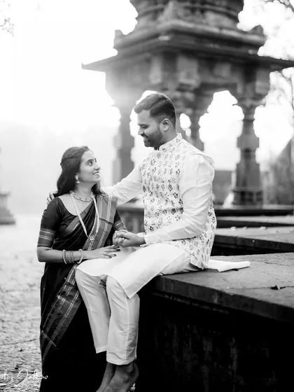 A quiet moment on the steps of a temple. This black and white image has a soft, hazy quality from the morning light, creating a dreamy and romantic atmosphere for the couple.