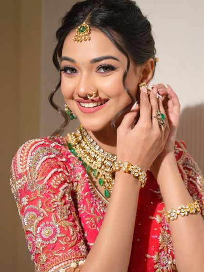 A candid moment of the bride adjusting her earring. Her genuine smile and the flawless makeup create a picture-perfect memory.