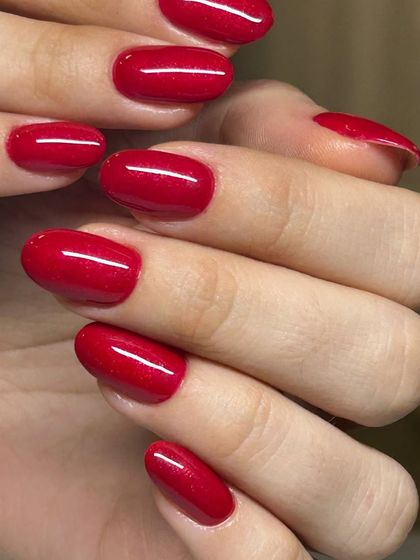 A classic red manicure with a subtle shimmer. The fine glitter particles give this timeless color a festive and glamorous twist.