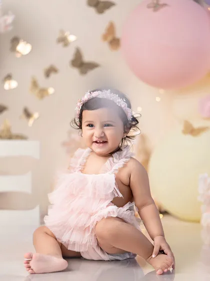 A sweet princess in a pink tutu, surrounded by butterflies. A magical first birthday portrait.