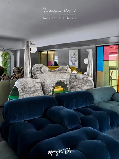A view of the TV lounge showing the deep blue velvet B&B Italia sofa in front of the Monster Console. The colorful stained glass partition in the background adds another layer of texture and vibrancy.