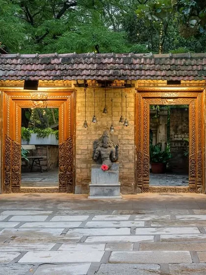 The entrance to one of our courtyards, with its antique carved doors and stone deity, sets a tone of reverence and heritage from the moment you step through.