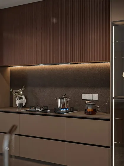 This angle highlights the seamless integration of the glass crockery unit and the cooking hob. The handleless drawers maintain a clean, uninterrupted flow across the lower cabinets.