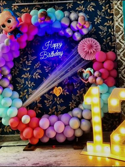 A vibrant Cocomelon-themed ring decoration for a 12th birthday. The colorful balloon ring is topped with a Cocomelon character and paired with large marquee numbers, creating a fun and modern party look.