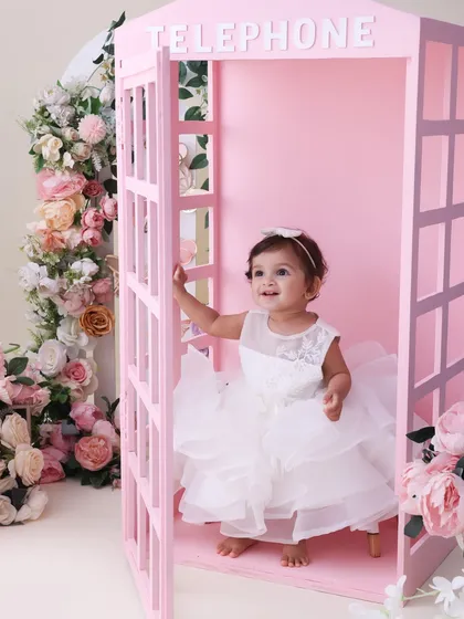 Peeking out of a fairytale. This candid shot of a little girl in the pink telephone booth is full of charm and curiosity. It’s these unposed moments that often become the most cherished.