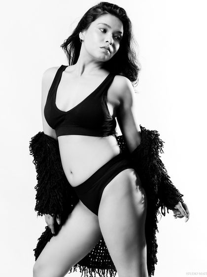 A candid-style black and white portrait. The movement in the hair and the relaxed pose give this shot a natural and spontaneous feel.