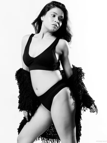 A candid-style black and white portrait. The movement in the hair and the relaxed pose give this shot a natural and spontaneous feel.