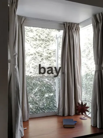 A cozy bay window seat we designed, creating the perfect nook for reading or enjoying the view. Simple curtains frame the window without blocking the light.