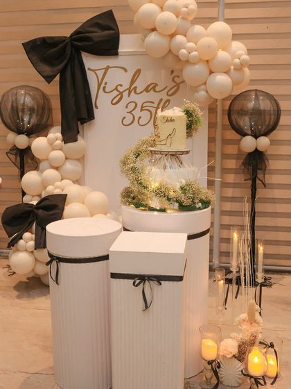Another angle of the bow themed birthday setup, showcasing the balance between the balloon arch, the cake display, and the candle arrangements. Every element is placed with care to create a cohesive look.