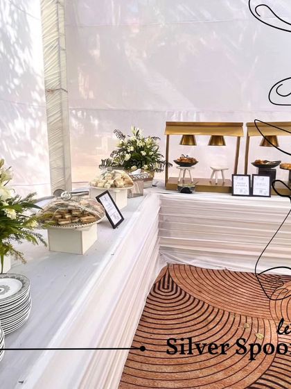 A clean and elegant white-themed buffet setup, perfect for daytime events or prayer meetings. The minimalist aesthetic is complemented by fresh floral arrangements and high-quality serveware.