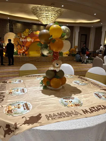 Another angle of the guest table setup, showing the themed tablecloth and balloon centerpiece with the main stage in the background.