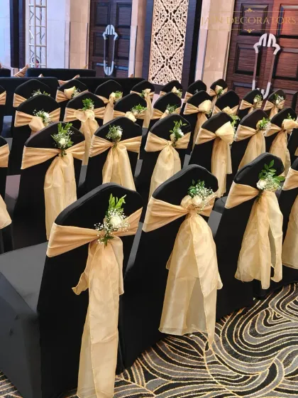 Every detail matters. For this event, I adorned each chair with a golden bow and a small, fresh floral arrangement, ensuring that even the seating was a beautiful part of the overall design.