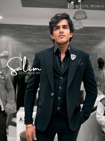 A client wearing a classic black three-piece suit. The addition of a small lapel pin adds a touch of personal style to this timeless ensemble.