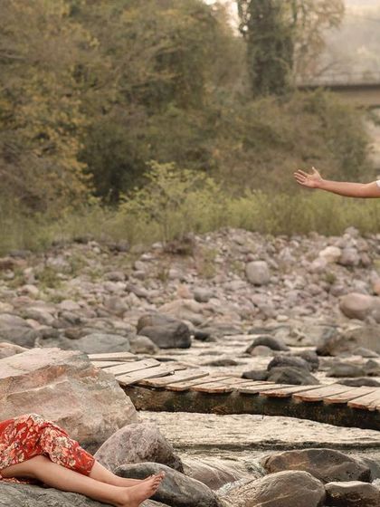A candid and joyful moment from a pre-wedding shoot by the river in Rishikesh.