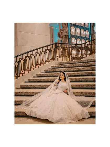 A fairytale bridal portrait. The bride seated on the steps, her gown spread around her, creates a truly magical image.
