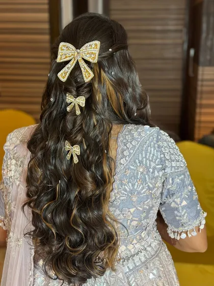 The full view of the cascading curls and bow accessories, a perfect hairstyle for a fun-filled sangeet night.