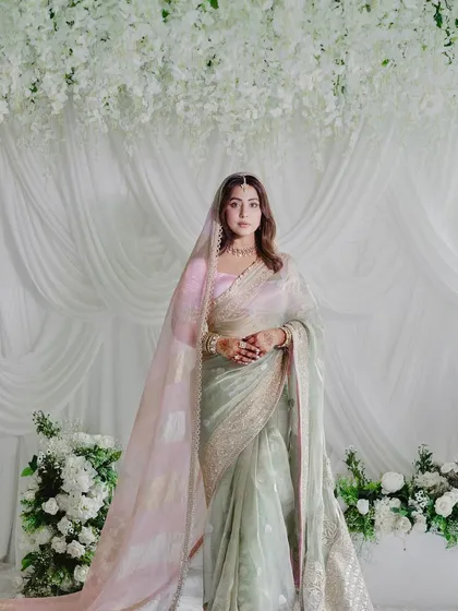 A full-length portrait of the bride against the elegant white backdrop. The design creates a clean and sophisticated frame that allows the bride's beauty and attire to shine.