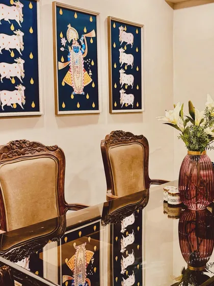 Sourcing the right art is like finding a hidden treasure. These traditional Pichwai paintings bring a story of devotion and culture to this dining space, perfectly complementing the classical carved chairs and creating a truly elegant atmosphere.