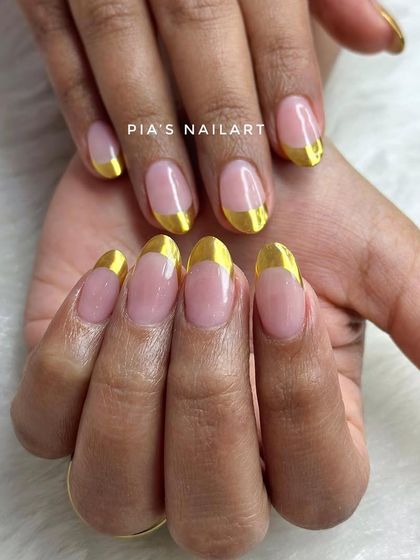 Clean and sharp. A classic French manicure gets a modern upgrade with a bold, reflective gold chrome tip.