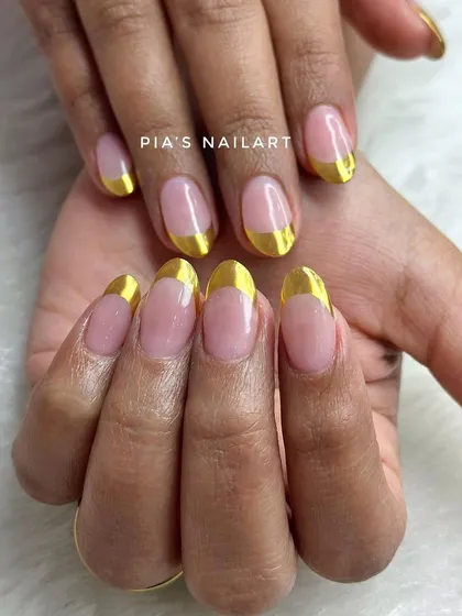 Clean and sharp. A classic French manicure gets a modern upgrade with a bold, reflective gold chrome tip.