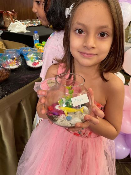 A proud little artist showing off the mini aquarium she created at our mermaid-themed party. These are always a huge hit and make for a magical take-home gift.