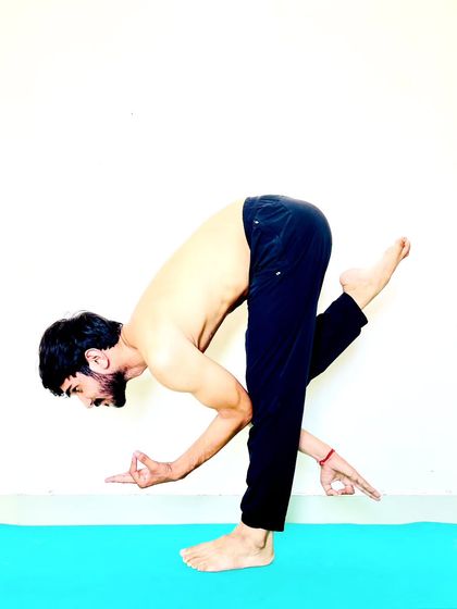 A creative standing balance that involves a bind, challenging both stability and flexibility.