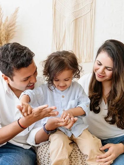 A family plays together during a relaxed, lifestyle studio session. The boho setup with neutral tones is perfect for these candid moments.