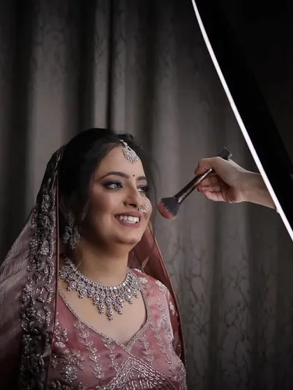 A behind-the-scenes moment of the makeup artist giving the final touches. This captures the transformation and the excitement before the main event.