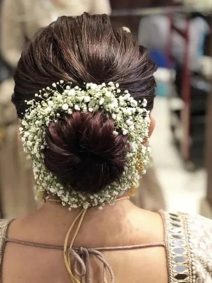 An elegant and intricate floral bun. I love creating these traditional hairstyles with a modern touch, using fresh baby's breath to create a soft, romantic frame for the formal updo.