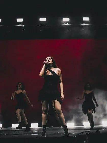 Dhvani Bhanushali owning the stage in a custom one-shoulder black top with fringe details. This look is all about movement, drama, and stage presence.