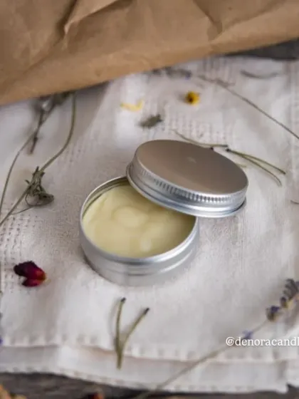 An aesthetic shot of the round solid perfume tin on a linen cloth with dried botanicals, perfect for creating a natural, artisanal brand image.