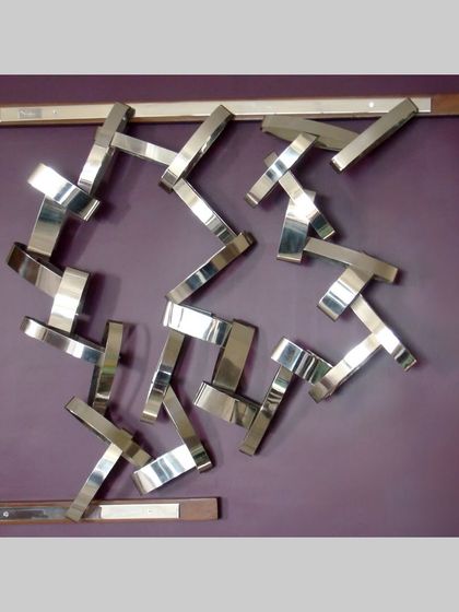 The full view of the early geometric piece, framed in wood, showcasing a rhythmic arrangement of steel forms.