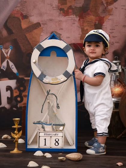 A proud little sailor standing tall. This shot captures his confidence and the charming details of his sailor outfit.