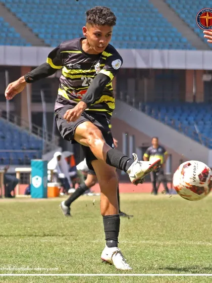 A player connects with the ball for a powerful shot on goal during a Football Delhi B Division match.