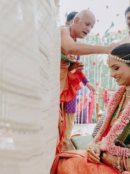 Blessings from the priest. The bride's serene expression is captured beautifully here. Her makeup look is traditional and respectful of the ceremony's sanctity.