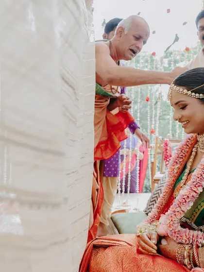 Blessings from the priest. The bride's serene expression is captured beautifully here. Her makeup look is traditional and respectful of the ceremony's sanctity.